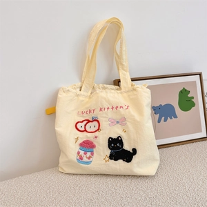 Detail of cute Lucky Kitten embroidery and milk jar design on cream canvas tote bag