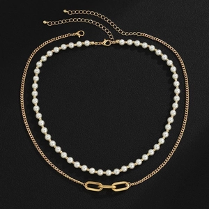 Detail of double-layer necklace with white pearls and gold-toned interlocking chains