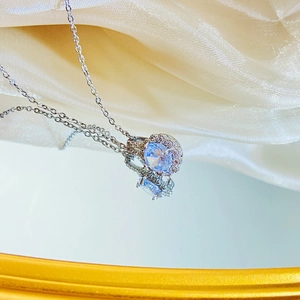 French luxury silver floral pendant necklace with oval purple gem on yellow fabric