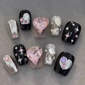 Detail of luxury handmade press-on nails with pink heart rhinestones and silver butterfly