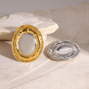 Detail of mixed-metal irregular oval stud earrings with textured gold and silver finish