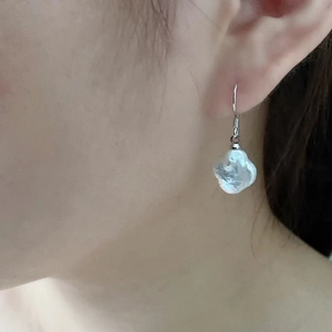 Baroque pearl clover drop earrings with silver needles shown worn on ear for women