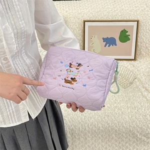 Detailweergave van de gewatteerde lavendel make-uptas met schattig hondenborduursel