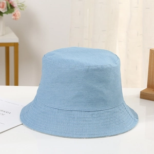 Detail of light blue denim bucket hat showing wide brim and fine stitching quality