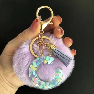 Détail du pompon violet et du porte-clés lettre C en résine avec sequins en cœurs