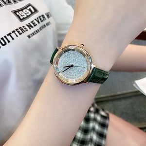 Detail of rose gold watch featuring a green leather strap and shimmering diamond-set dial