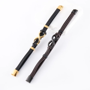 Dettaglio di bracciali infinity in pelle nero oro e marrone scuro con chiusura in metallo