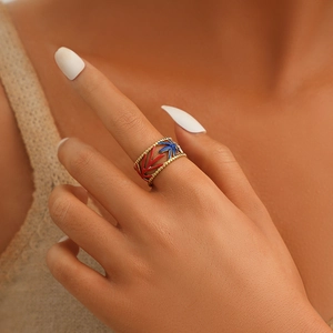 Gold leaf open ring with colorful red and blue enamel inlays on model's finger
