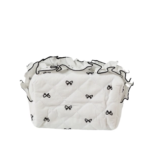 White quilted makeup bag with black bow prints and ruffled trim, sweet girl style pouch
