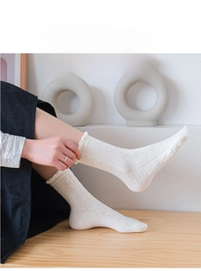 Primo piano di calzini in cotone bianco con motivi a cuore traforati e bordi arricciati