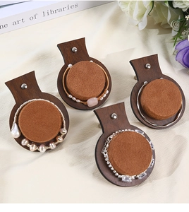 Detail of walnut wood jewelry trays with beige velvet cushions for bracelet display