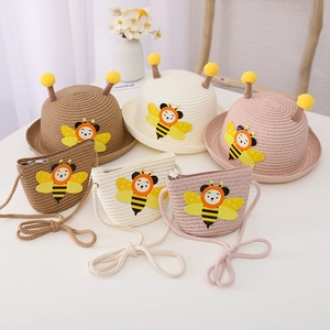 Close-up of children straw hat and bag set with cute bee decor in brown beige and pink