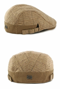 Detail view of the vintage plaid wool flat cap with metal logo plate and adjustable buckle