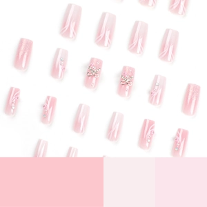 Pink gradient coffin fake nails with glitter, metallic bows, and pearl accents