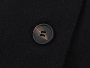 Close-up of a marbled black button on a premium wool coat with a soft texture
