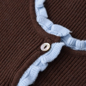 Slim fit knit top in dark coffee with light blue ruffle trim and shell button detail