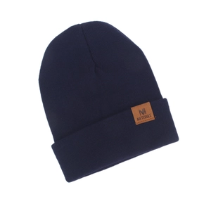 Close-up detail of navy blue knit beanie hat featuring a brown METERULE leather patch