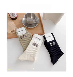 Detailed embroidery of vintage camping lamp and text on cotton ribbed crew socks