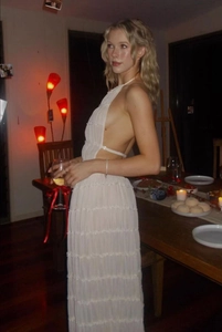 Detail of white pleated halter dress featuring a backless tie-up design and long skirt