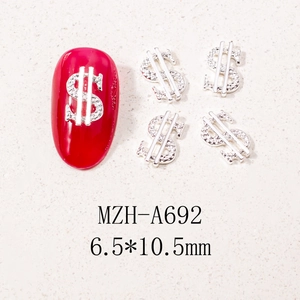 Macro detail of silver dollar sign nail art charms with crystals on red manicure