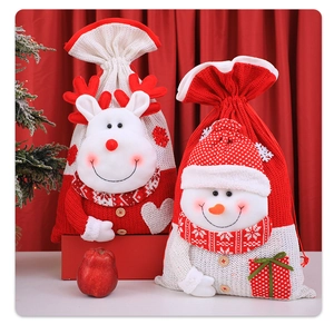 Dettaglio di sacchetti regalo di Natale in maglia con applicazioni 3D di renne e pupazzi di neve