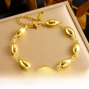 Close-up of golden stainless steel oval bead chain bracelet on a leather jewelry box