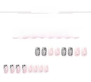 Vue détaillée d'ongles rose clair avec pointes françaises, strass et motifs zébrés