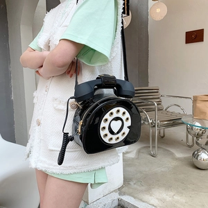 Detail of creative patent leather telephone bag with heart dial and spiral cable