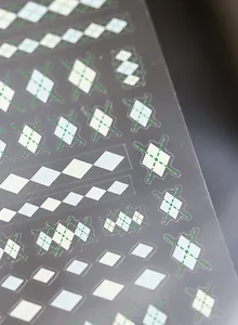 Macro shot of Argyle pattern nail stickers with green and blue diamond textures