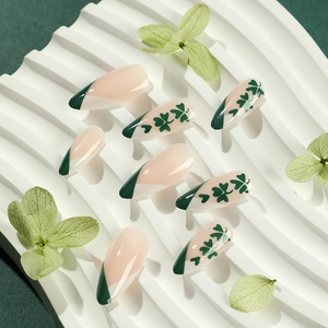French green St. Patrick's Day press on nails with lucky clover patterns on almond tips