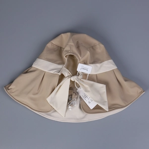 Close-up of khaki sun hat with wide brim, white decorative ribbon and bow tie detailing