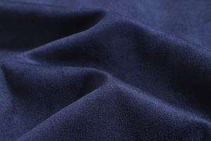 Macro shot of dark blue suede fabric texture on a slim-fit long-sleeve jacket