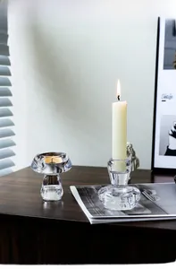 Minimalistische Pilz-Kerzenhalter aus Glas auf dunklem Holztisch mit Licht und Schatten