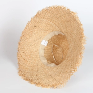 Détail du chapeau de paille en raphia à large bord montrant la fibre naturelle et le bord brut