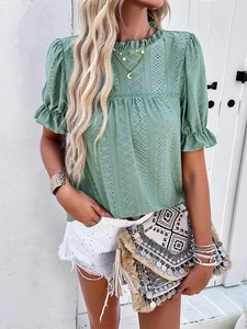 Detail of green eyelet embroidery top with puff sleeves in Bohemian vacation style