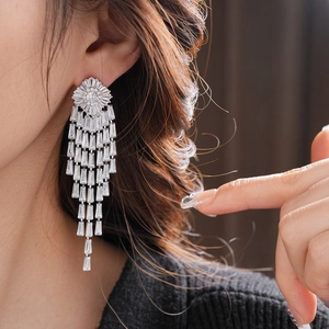 Close-up of silver tassel earrings with sparkling cubic zirconia on female model