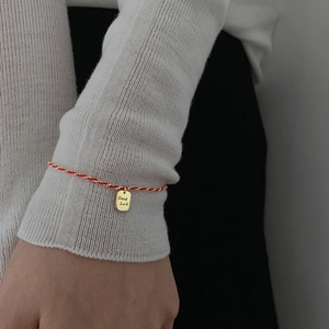 Rotes geflochtenes Armband mit goldenem Good Luck Anhänger für Damen