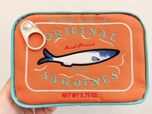 Close-up of sardines can cosmetic bag featuring intricate embroidery and realistic pull tab