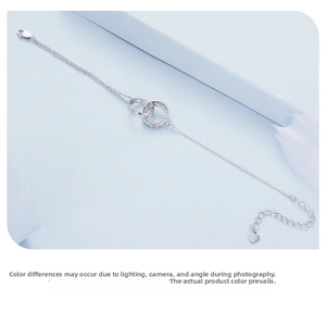 Detail of S925 sterling silver double-ring bracelet featuring pavé zircon and heart charm