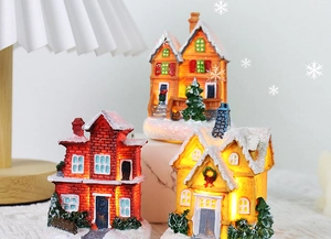 Close-up of lighted resin Christmas village houses with snowy texture and LED glow