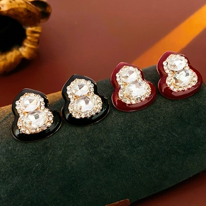 Detailed view of red and black enamel gourd earrings with sparkling crystals