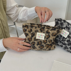 Macro detail of plush leopard print makeup bag with high-quality zipper and woven label