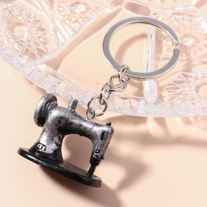 Macro detail of vintage sewing machine keychain with antique silver metal finish