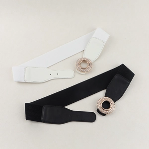 Detail of elastic waist belts in black and white with rhinestone circle buckles