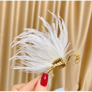 Detailed close-up of a gold flamingo brooch featuring soft white feathers and zircon accents