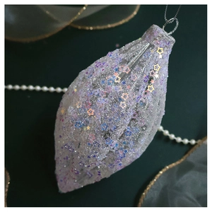 Close-up of sparkling white teardrop ornament with iridescent star sequins and silver cord