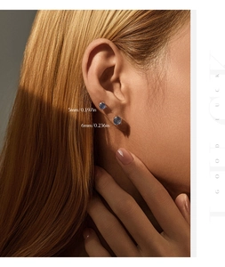Detailed view of 5mm and 6mm dark blue gemstone earrings on a female model