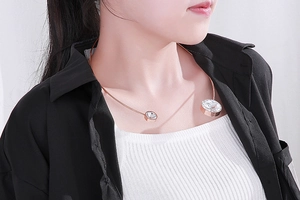 Detail of rose gold stainless steel neck ring featuring large zircon stone accents