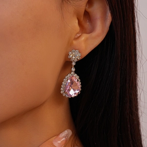Gros plan de boucles d'oreilles poire roses avec diamants brillants sur le mannequin