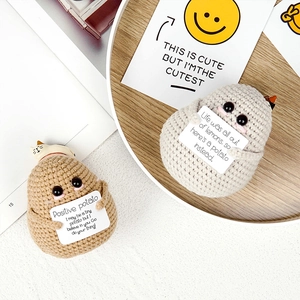 Detail von zwei handgehäkelten Kartoffelpuppen mit Motivationskarten auf einem Holztablett